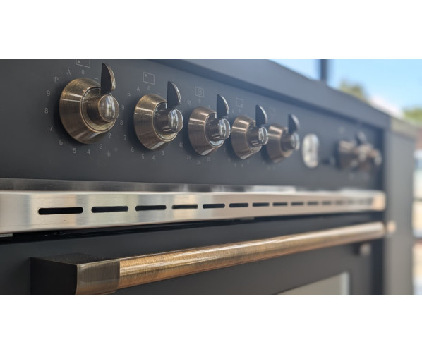 De STEEL X9F‑5FIW inductie fornuis in mat zwart met bronzen knoppen