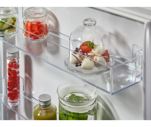 Koelkast TC6LS181ES bovengedeelte met glazen schappen en verzameling flessen en ingrediënten