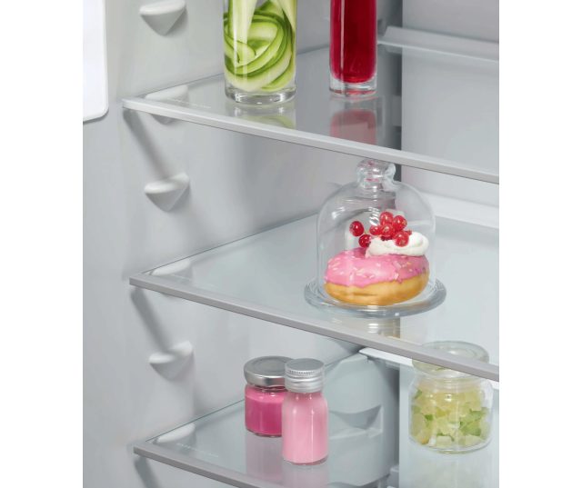 Detail middelste schap met glazen bak met dessert en gekleurde flesjes