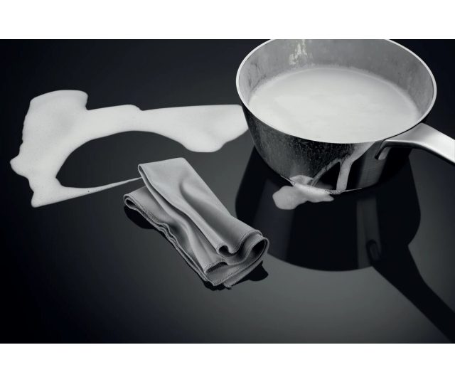 Accessoires voor inductie kookplaat, melkpan, spatelschep en schoonmaakdoek