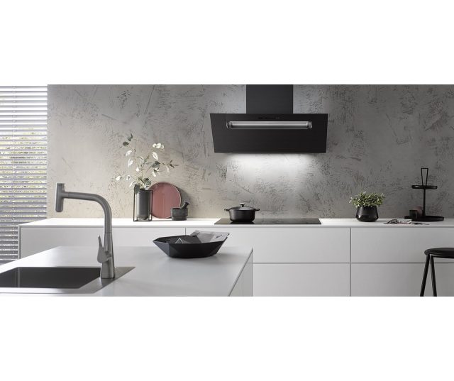 Berbel BKH 60 EG 2 zilvermetallic afzuigkap in moderne keuken boven kookplaat geïnstalleerd, vooraanzicht met LED-verlichting aan.
