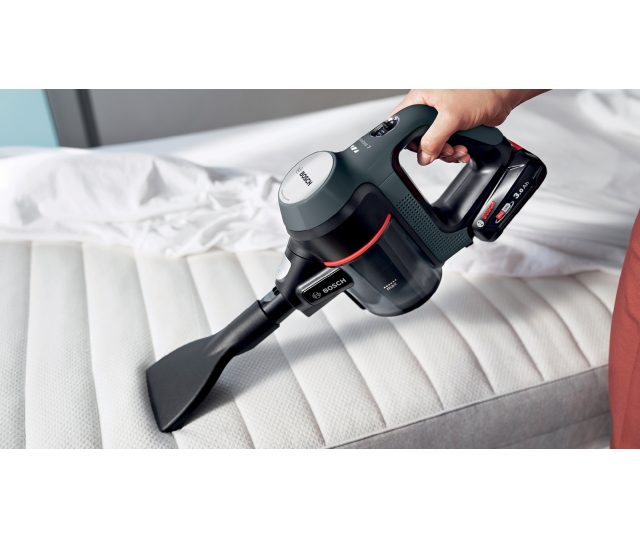 Bosch BBS712A handheld stofzuiger in gebruik op gestoffeerde matras