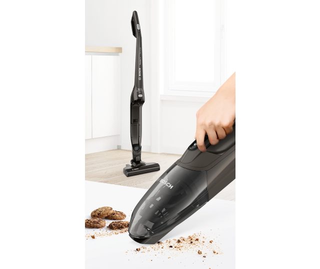 Bosch BCHF2MX16 stofzuiger in gebruik op houten vloer met strooisel en koekjes