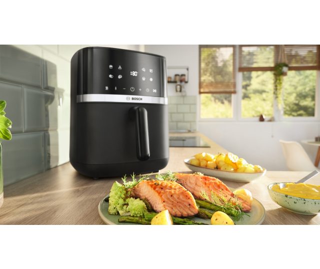 Bosch MAFS2462B airfryer in keukenomgeving met bereide zalm en groenten op borden