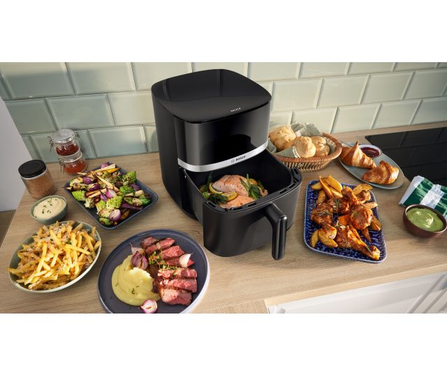 Bosch MAFS2462B airfryer geopend met bereide maaltijden en diverse gerechten eromheen