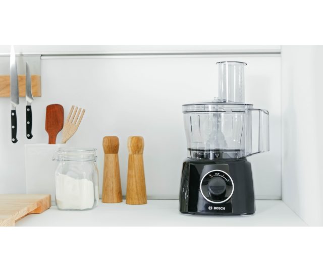 Bosch MCM3201B keukenrobot in keukensetting op aanrecht naast keukengerei en ingrediënten