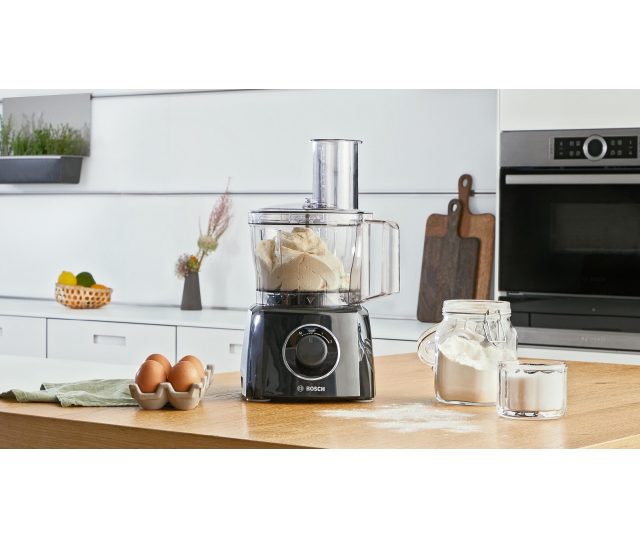 Bosch MCM3201B keukenrobot in gebruik met deeg in mengkom op houten werkblad