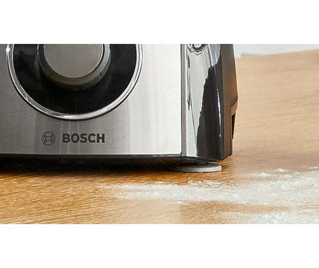 Bosch MCM3PM386 keukenmachine detail zijkant met Bosch-logo en bedieningsknop op werkblad
