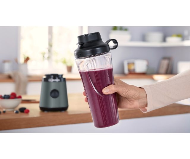 Bosch MMB2111S to-go beker gevuld met paarse smoothie in hand getoond met sluiting