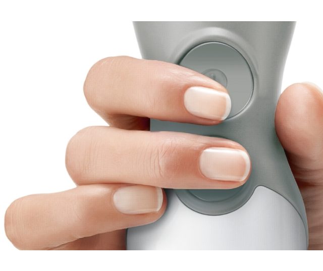 Close-up hand bedient bovenste snelheidsknop van Bosch staafmixer
