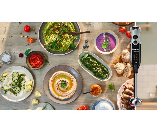 Bosch MSM67160 staafmixer met gegarneerde schotels: salade, hummus, smoothie bowl en brood op tafel