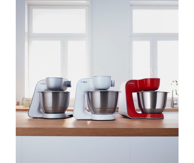 Drie Bosch MUM58L00 keukenmachines in creme, wit en rood naast elkaar