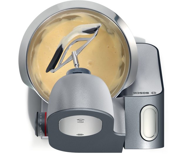 Bosch MUM59S81DE topweergave met geopende mengkom vol beslag en twee gardes erin