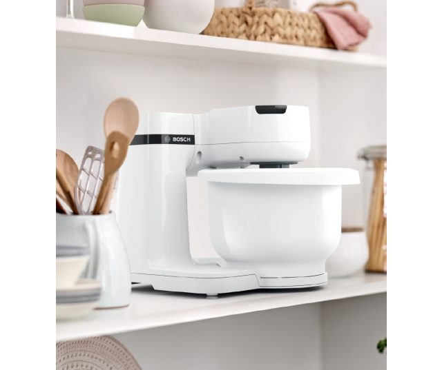 Bosch MUMS2AW01 keukenmachine in keukenomgeving op werkblad tussen keukengerei en decoratie