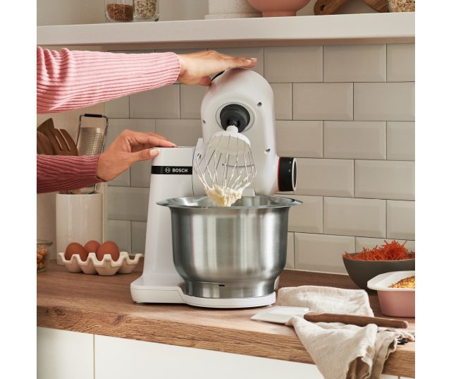 Bosch MUMS2EW00 keukenmachine in gebruik met garde waarbij deegbestanddelen worden gemengd