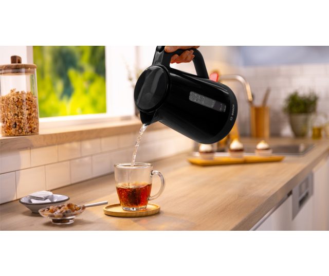 Bosch TWK1M123 waterkoker in gebruik met stoom uit tuit boven kopje thee