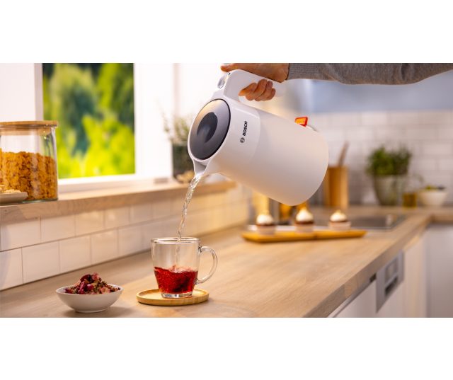 Bosch TWK2M161 waterkoker wordt bediend en schenkt kokend water in glas