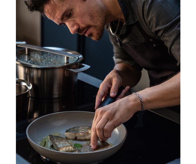 Fissler Ceratal Evo Classic koekenpan 28cm grijs in gebruik met gegrilde vis en kruiden op het fornuis