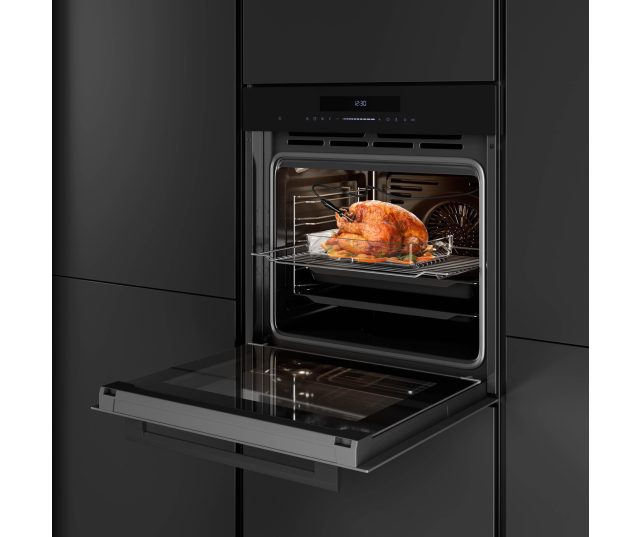 Inventum IOM6035GT geopende oven met geroosterde kip op draaihaak in keukensituatie
