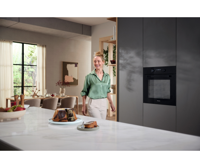 Miele H 2861-1 B 125 Edition oven geïnstalleerd in moderne keuken met geopende deur en brood in ovenkamer