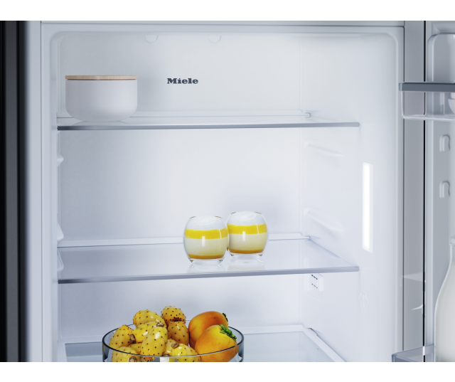 Miele K7125E koelkast bovenkant shelves leeg met witte schaal en gele drankjes