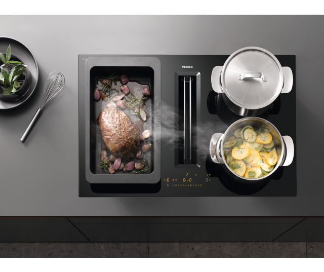 Miele KMDA 7473-1 FL Silence in gebruik met potten en pan, bovenaanzicht in keuken met afzuigingsuitgang zichtbaar