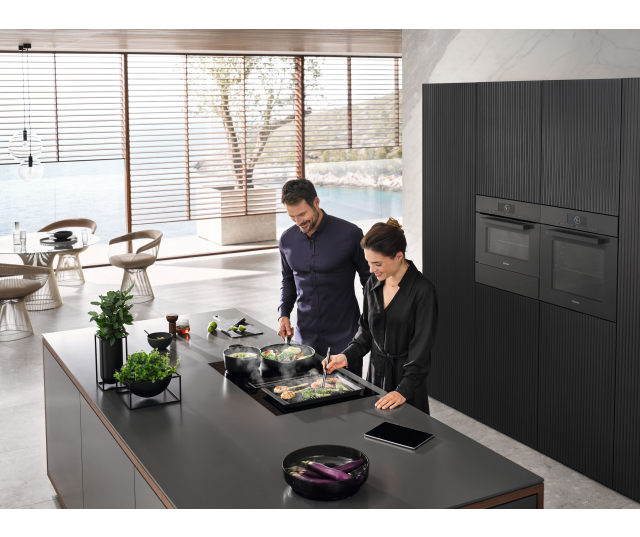 Miele KMDA 7473-1 FL Silence ingebouwd in moderne keuken, twee personen aan het koken op het apparaat