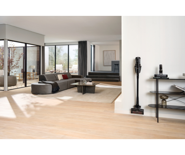 Miele TriflexHX3Aqua stofzuiger staande in moderne woonkamer naast meubels aan muur