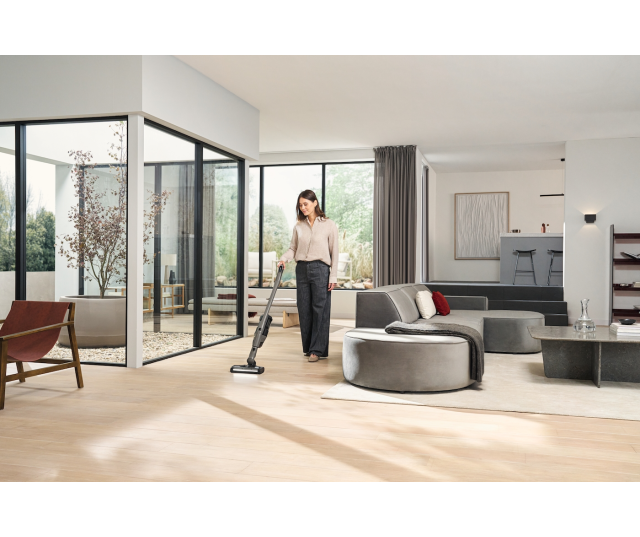 Miele TriflexHX3Hardfloor in gebruik door vrouw op houten vloer in woonruimte