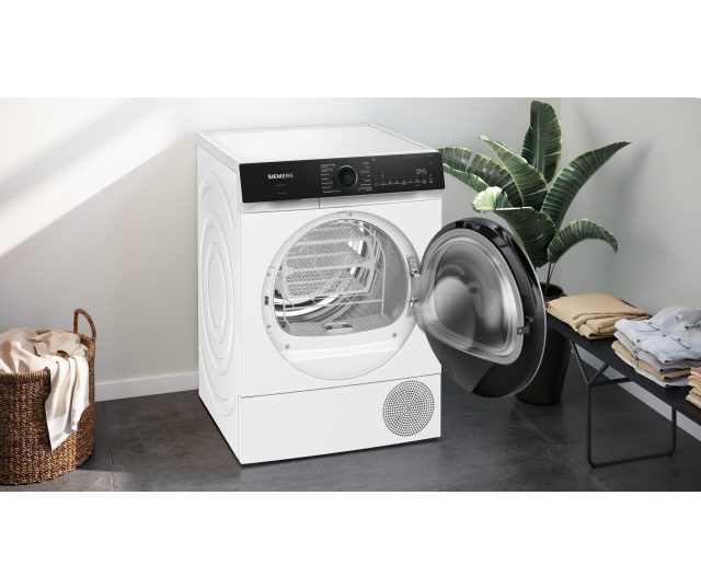Siemens WQ46N2C9NL in huiskamer met geopende deur en volgeladen wasmand ernaast