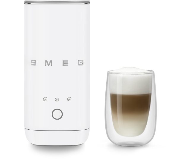 Smeg MFF02WHMEU melkopschuimer naast cappuccinoglas met melkschuim erin