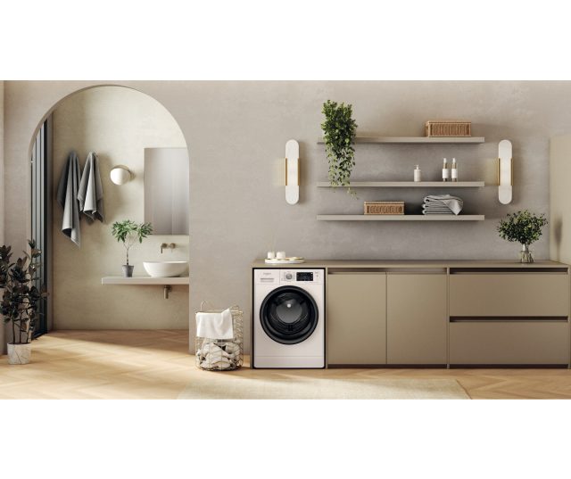 Whirlpool wasmachine in moderne badkamerinrichting tegen kastenwand geplaatst