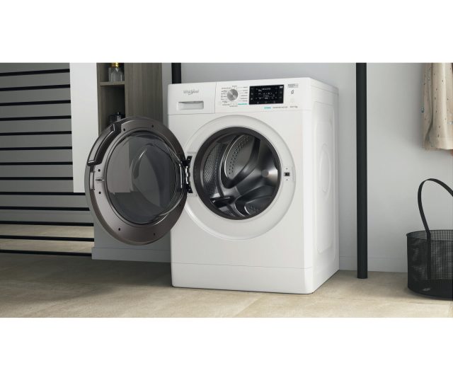 Whirlpool FFWDD 1076258 SV EE wasdroger in moderne keukenkamer met wandkasten en hangende kleding