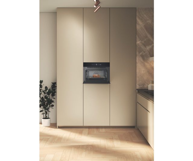 Whirlpool WCW46HMB inbouw in keukenkast tussen beige kasten in keukenruimte