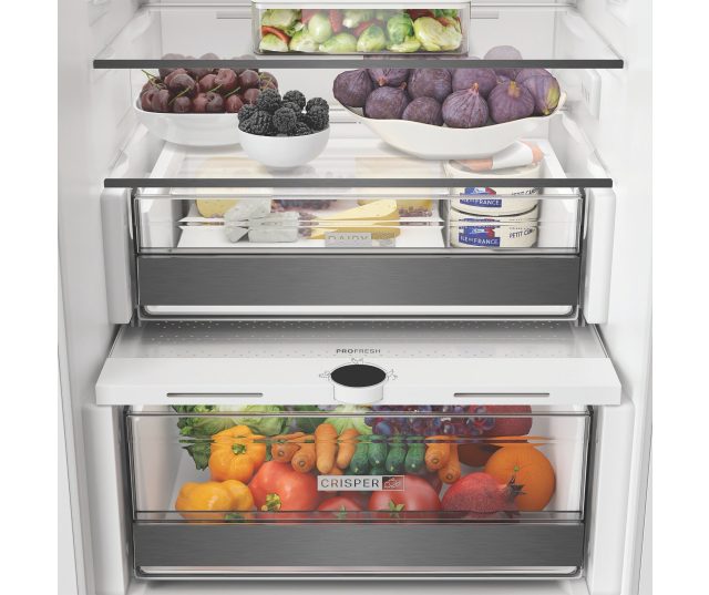 Whirlpool WHK2 5293B5E bovenste koelkastafdeling interieur met geopende laden en schappen met verse producten