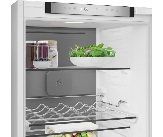 Whirlpool WHK2 5294 B6E1 koelkastgedeelte geopend met zichtbare schappen, wavinglades en bewaarvakken