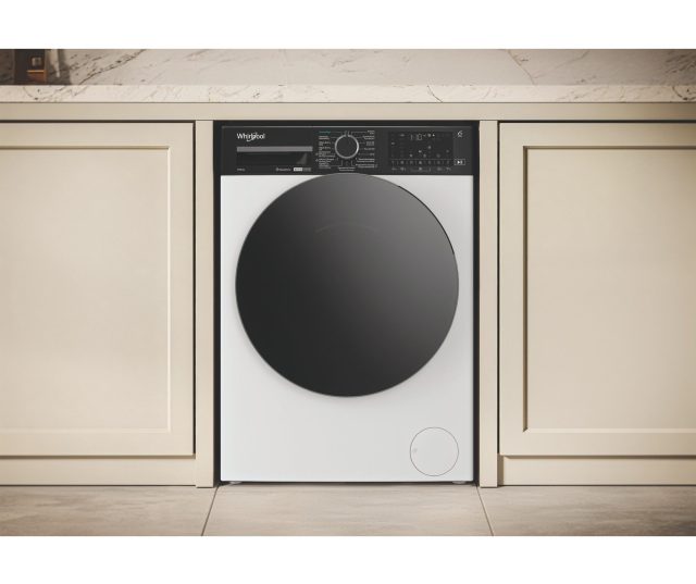 Whirlpool was/droogcombinatie in beige keukensetting tussen kastdeuren gepositioneerd
