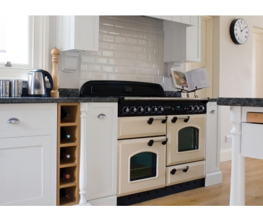 De FALCON Classic 110 gas/elektro afgebeeld in de kleur creme en geplaatst in een bijpassende keuken