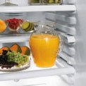 De binnenzijde van de koelkast heeft in hoogte verstelbare leggers van veiligheidsglas