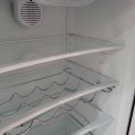 Het luxe interieur van de bruine PELGRIM retro koelkast met glazen leggers en flessenrek