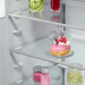 Detail middelste schap met glazen bak met dessert en gekleurde flesjes