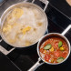 Aga eR7i1505ERIO kookplaat met twee pannen met pasta en tomatensaus in gebruik