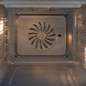 Interieur van Bertazzoni FPRO6117CTX3 met verlichte oven en braadpan met geroosterd vlees