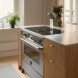 Bertazzoni MASCH94I1EXT ingebouwd in keukenopstelling tussen houten kasten, aanrechtlevel
