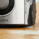 Bosch MCM3PM386 keukenmachine detail zijkant met Bosch-logo en bedieningsknop op werkblad