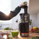 Gebruiker voert groen blad in toegangsopening Bosch MESM731M slow juicer