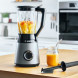 Bosch MMB6172S blender in moderne keuken op houten werkblad, kan met geel vruchtensap en mengstaaf ernaast