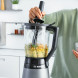 Bosch MMB6172S blender in gebruik met groen-grove ingrediënten in kan, staafmixer ernaast op keuken