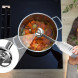 Close-up van mengvoet in werking in pan met groentebouillon op kookplaat