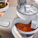 Bosch MUM5XW10 keukenmachine met geopende mengkom en mengwerktuig, ingrediënten zichtbaar